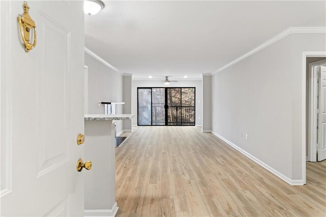 unfurnished living room featuring crown molding, ceiling fan, and light hardwood / wood-style floors