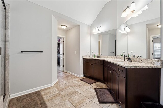 bathroom with a notable chandelier, walk in shower, vanity, and vaulted ceiling