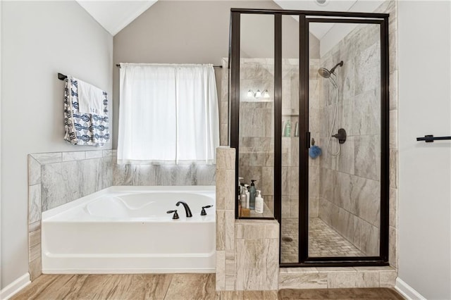 bathroom featuring independent shower and bath and vaulted ceiling