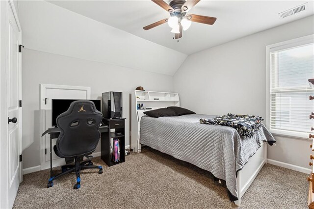 carpeted bedroom with ceiling fan and vaulted ceiling