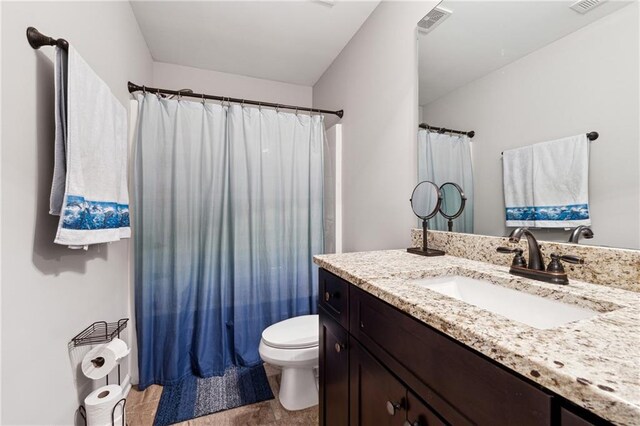 bathroom featuring tile patterned flooring, vanity, and toilet