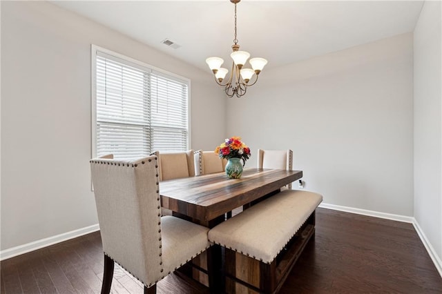 dining room with an inviting chandelier and dark wood-type flooring