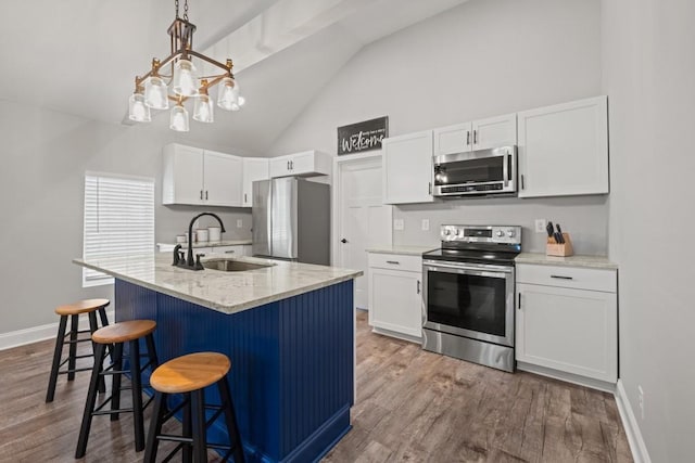 kitchen with a sink, white cabinets, stainless steel appliances, and dark wood-style flooring