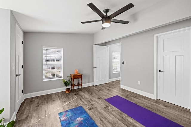 workout area featuring baseboards, ceiling fan, and wood finished floors