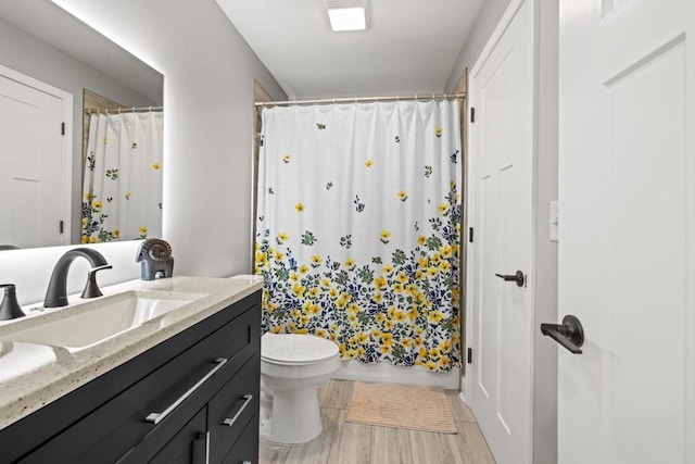 bathroom featuring vanity, a shower with shower curtain, wood finished floors, and toilet
