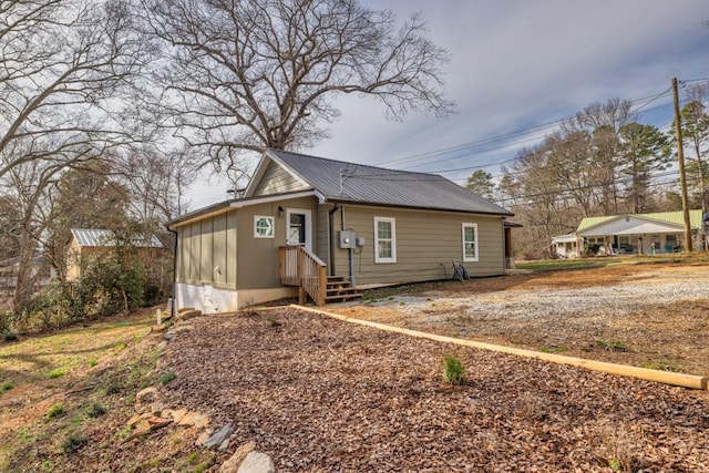 exterior space with board and batten siding and metal roof