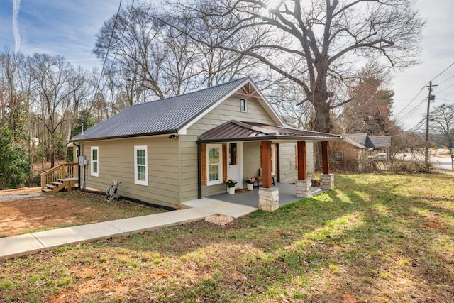 bungalow with a front lawn and metal roof