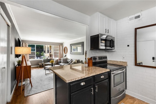 2240 Cheshire Bridge Rd NE Unit 206, Atlanta, GA 30324 - kitchen with stainless steel appliances, dark cabinets, white cabinetry, light stone countertops, and open floor plan