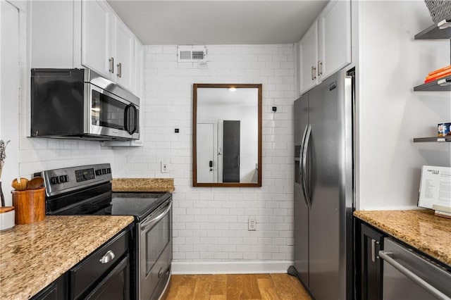2240 Cheshire Bridge Rd NE Unit 206, Atlanta, GA 30324 - kitchen with appliances with stainless steel finishes, open shelves, white cabinets, light wood-type flooring, and light stone countertops