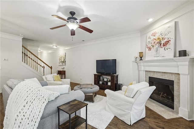13468 Gardiner Ln, Alpharetta, GA 30004 - living room with a ceiling fan, wood finished floors, ornamental molding, stairway, and a tile fireplace