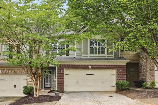 13468 Gardiner Ln, Alpharetta, GA 30004 - view of front facade featuring brick siding, concrete driveway, an attached garage, and roof with shingles
