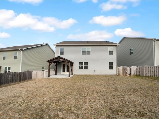 rear view of house featuring a fenced backyard, a patio, a gazebo, and a lawn