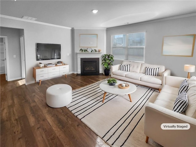 living area featuring baseboards, visible vents, wood finished floors, crown molding, and a fireplace