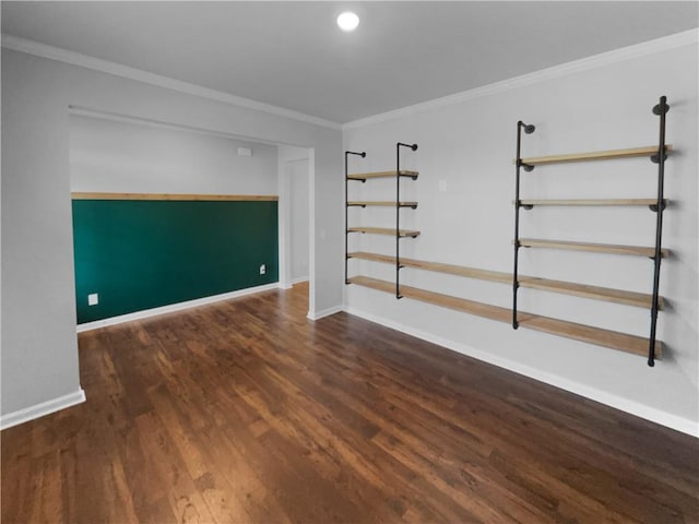 empty room featuring ornamental molding, baseboards, and wood finished floors