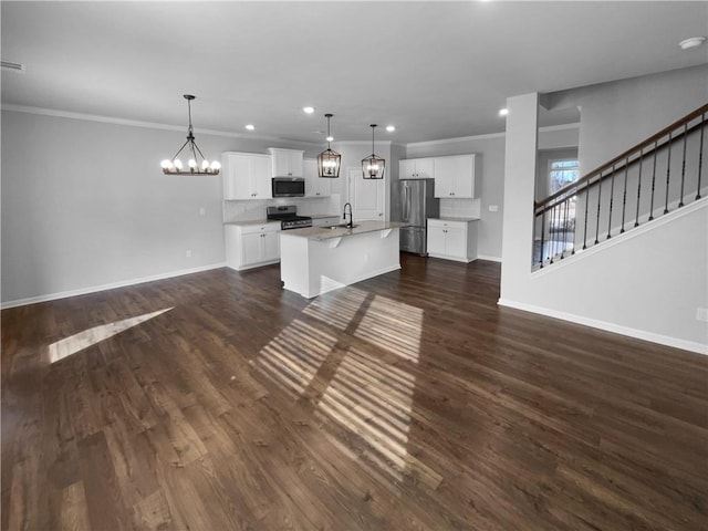 unfurnished living room with baseboards, dark wood-style floors, an inviting chandelier, stairs, and a sink