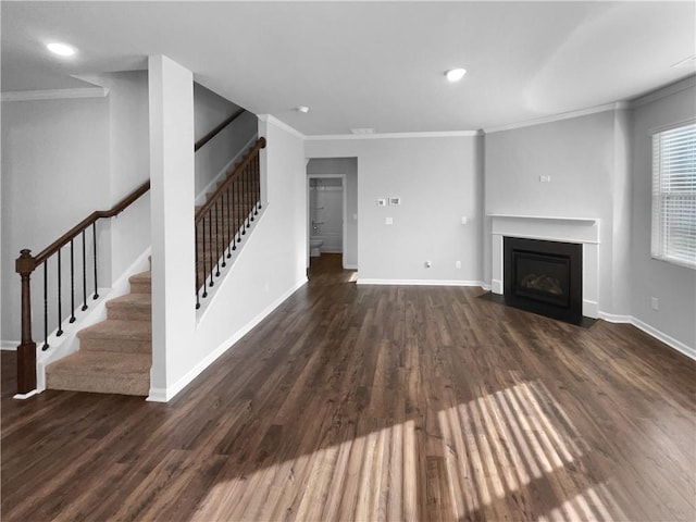 unfurnished living room with a fireplace with flush hearth, ornamental molding, and wood finished floors