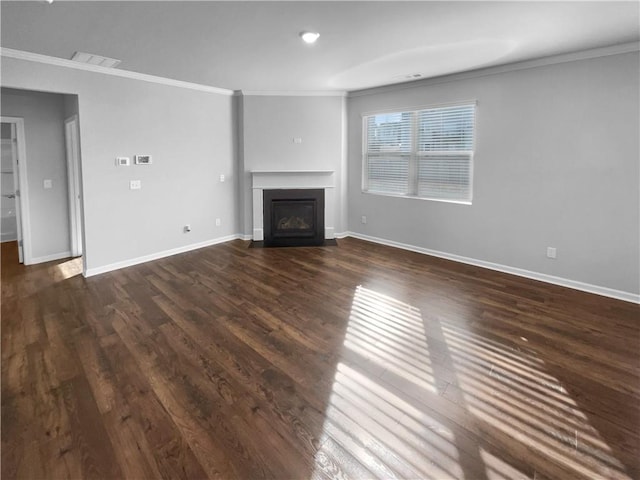 unfurnished living room with baseboards, a fireplace, dark wood finished floors, and crown molding