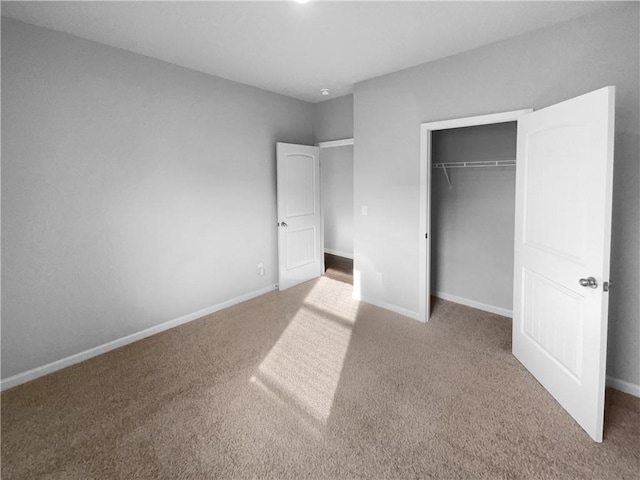 unfurnished bedroom featuring carpet floors, a closet, and baseboards