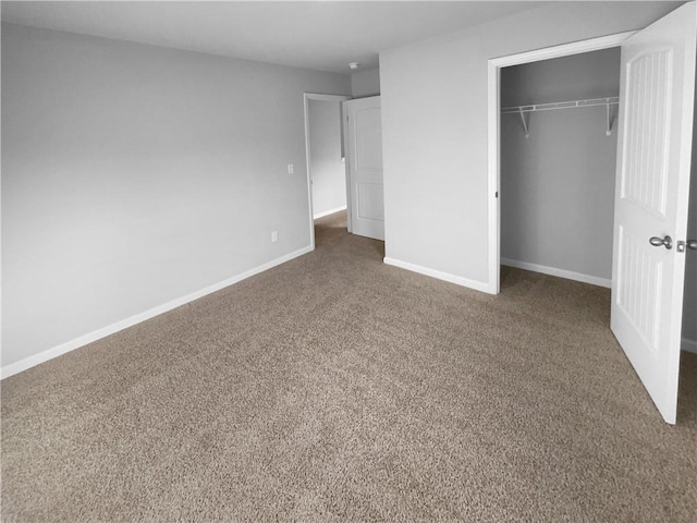 unfurnished bedroom featuring carpet, a closet, and baseboards