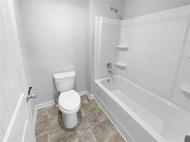 bathroom with toilet, baseboards, and bathing tub / shower combination