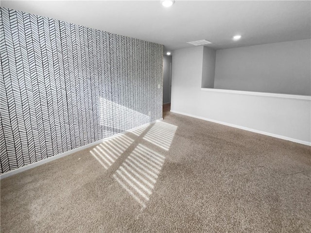 carpeted empty room with baseboards, visible vents, and recessed lighting