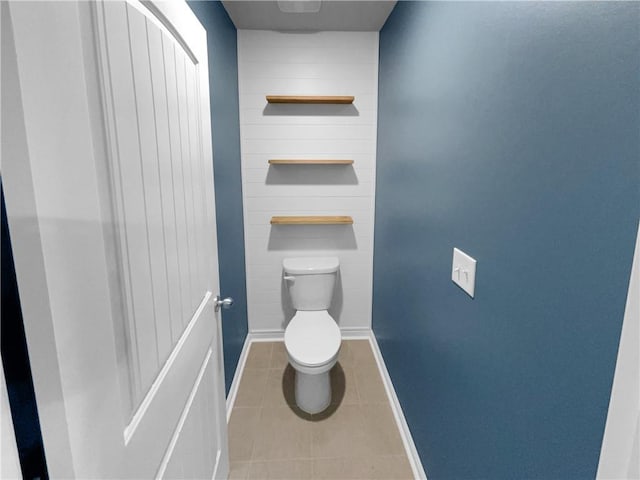 bathroom with baseboards, toilet, and tile patterned floors