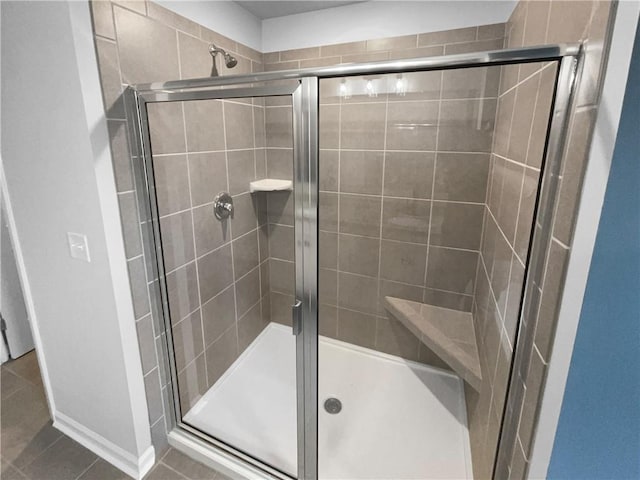 full bath featuring tile patterned flooring and a shower stall