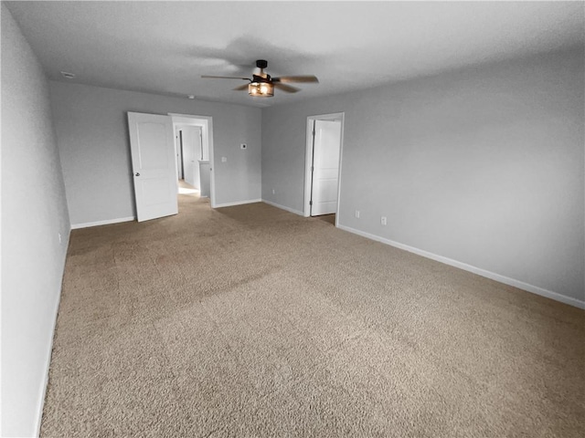 unfurnished room with carpet flooring, ceiling fan, and baseboards