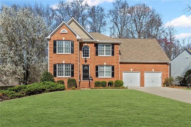 colonial house featuring brick siding, an attached garage, concrete driveway, and a front yard