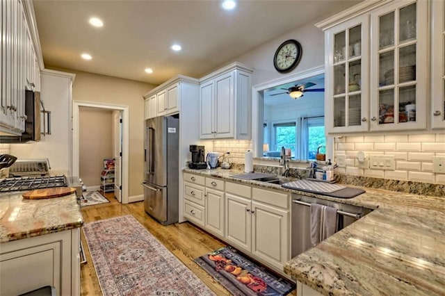 502 Cottage Crest Dr, Clarkesville, GA 30523 - kitchen with appliances with stainless steel finishes, a sink, tasteful backsplash, light wood-style flooring, and light stone countertops