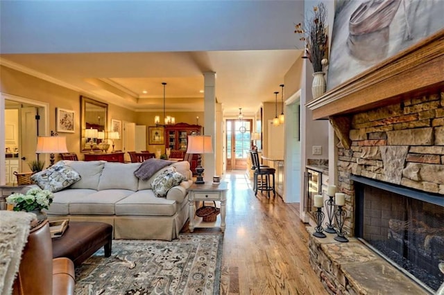 502 Cottage Crest Dr, Clarkesville, GA 30523 - living room with ornamental molding, light wood finished floors, a chandelier, a tray ceiling, and a fireplace