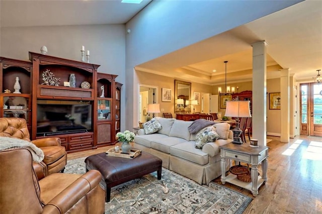 502 Cottage Crest Dr, Clarkesville, GA 30523 - living room featuring a chandelier, crown molding, wood finished floors, decorative columns, and a tray ceiling