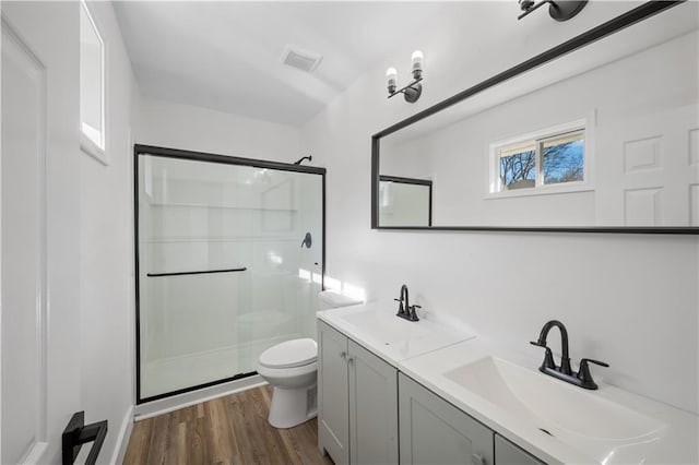 bathroom featuring hardwood / wood-style floors, vanity, toilet, and an enclosed shower