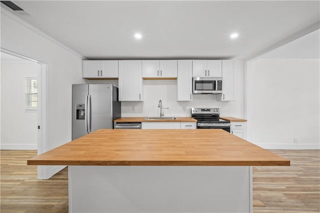 kitchen featuring white cabinets, light hardwood / wood-style floors, sink, and appliances with stainless steel finishes