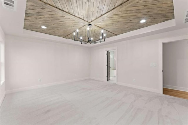 carpeted spare room with visible vents, a raised ceiling, wood ceiling, and baseboards