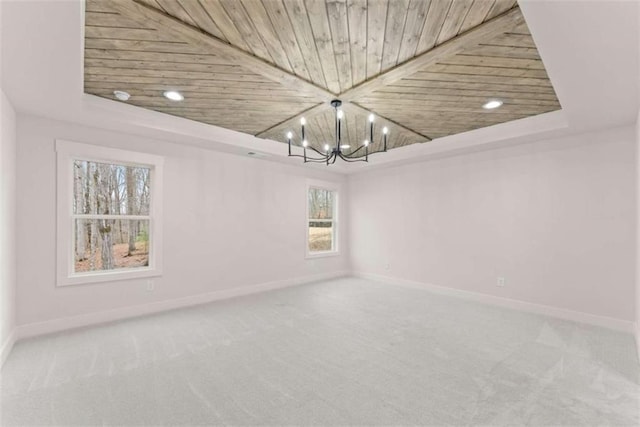 unfurnished room featuring baseboards, wooden ceiling, an inviting chandelier, carpet, and a tray ceiling