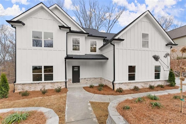 modern inspired farmhouse featuring board and batten siding and a shingled roof