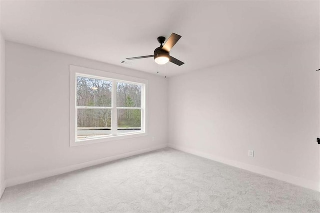 unfurnished room with visible vents, carpet floors, a ceiling fan, and baseboards