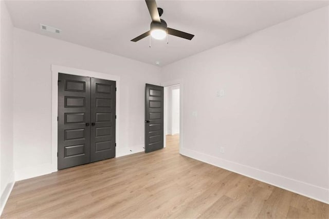 unfurnished bedroom with visible vents, light wood-style flooring, and baseboards