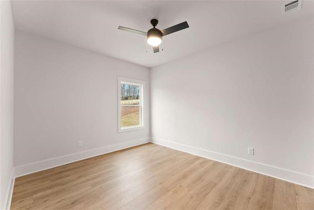 unfurnished room featuring ceiling fan, light wood-type flooring, visible vents, and baseboards