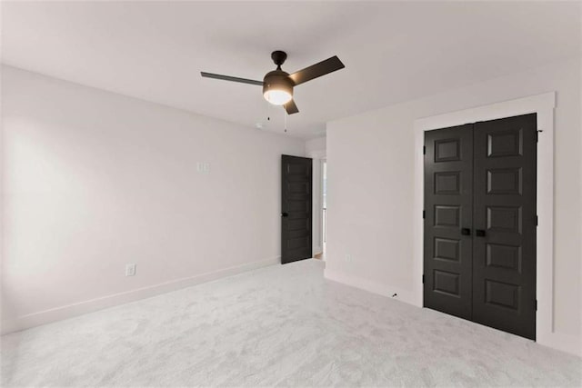 interior space with carpet floors, a closet, baseboards, and a ceiling fan