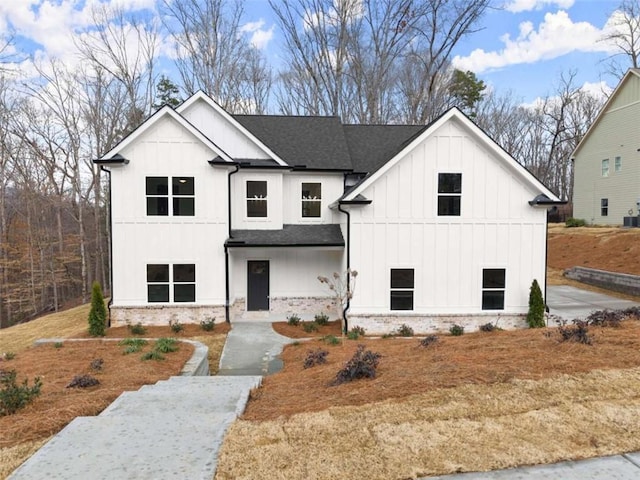 modern inspired farmhouse featuring board and batten siding and a shingled roof