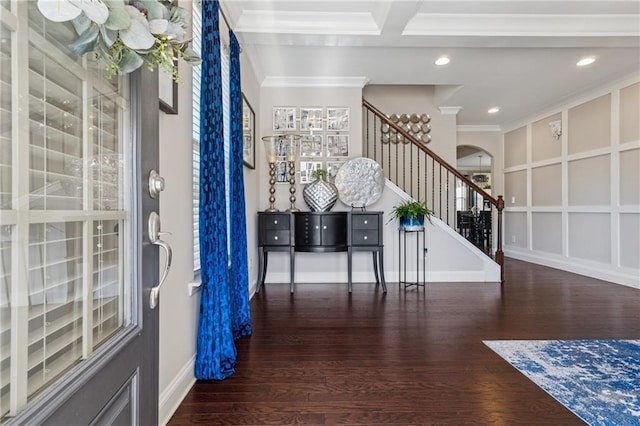 foyer with stairway, wood finished floors, arched walkways, crown molding, and a decorative wall