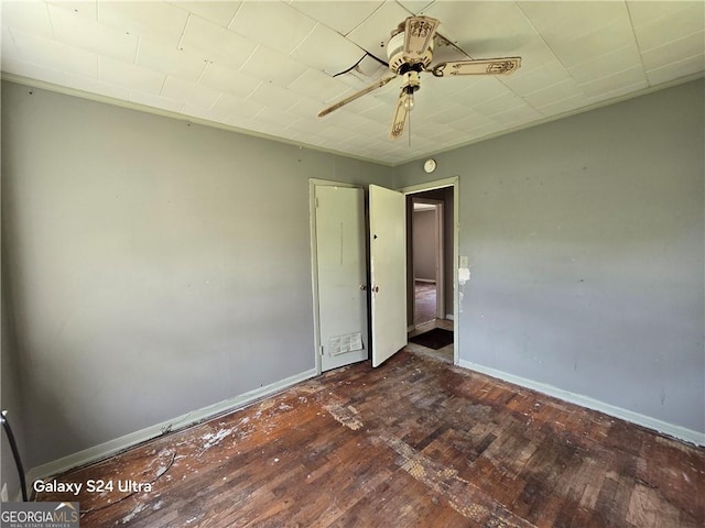 1243 Hill St NW, Conyers, GA 30012 - empty room with dark wood-style floors, a ceiling fan, and baseboards