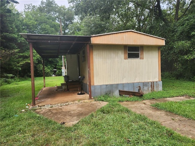 view of outdoor structure with a carport and a yard