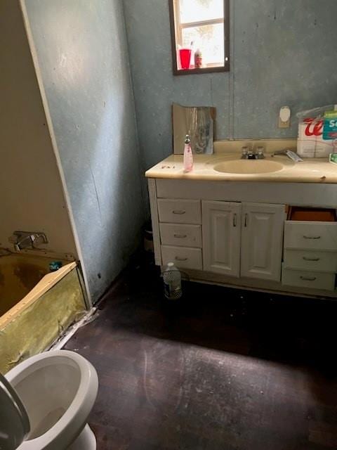 bathroom featuring vanity, a bathtub, and toilet