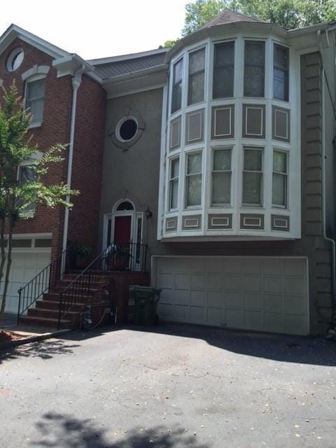 view of front of home with driveway and brick siding