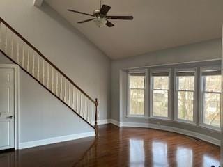 unfurnished living room featuring ceiling fan, wood finished floors, high vaulted ceiling, baseboards, and stairs