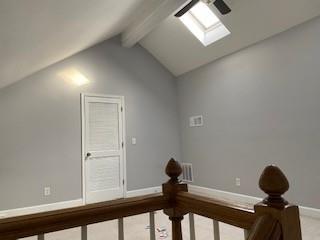 bonus room featuring vaulted ceiling with skylight and baseboards