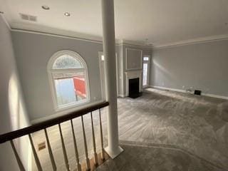 interior space with ornamental molding, a fireplace, carpet flooring, and baseboards